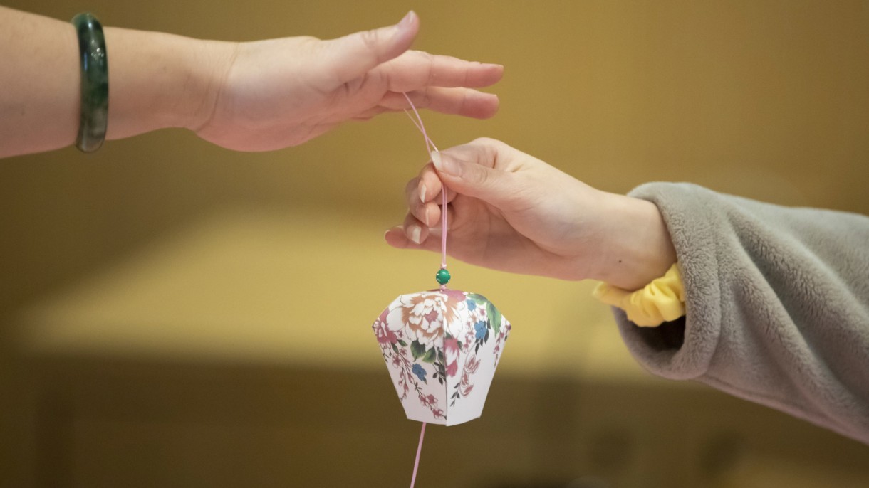 Hands holding an Asian decoration