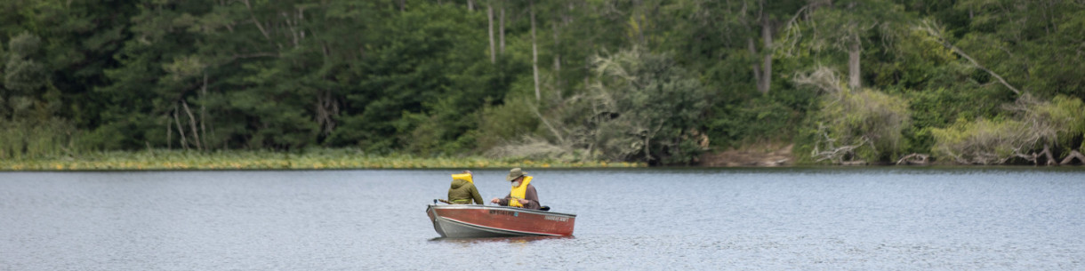 Two people sitting in a boat on a lake