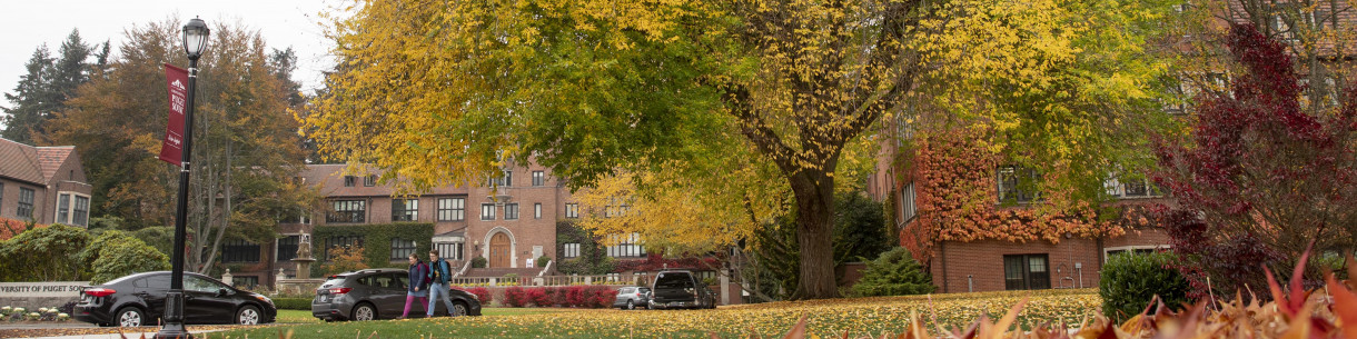 People walking across campus during Fall season colors