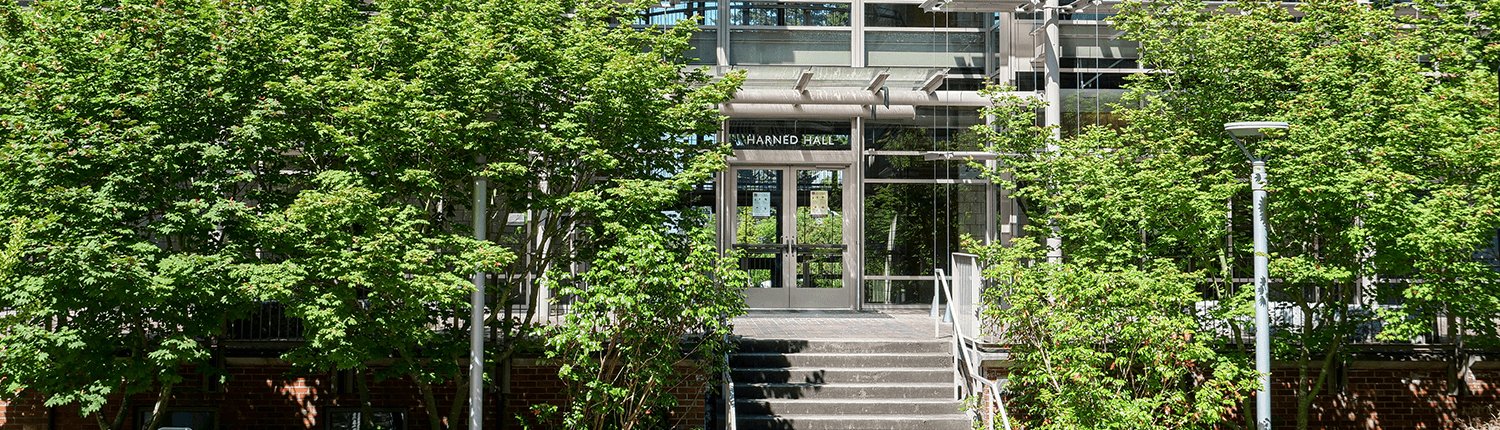 Image of Harned featuring lush green foliage and the center entrance. 