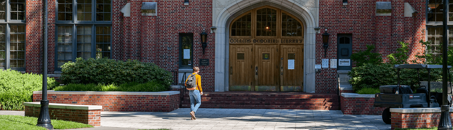 Image of the Library featuring a student walking towards the front entrance.