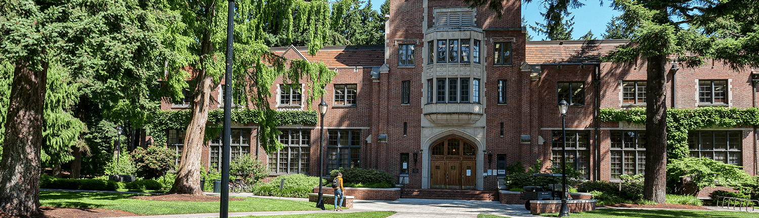 Image of the Library featuring a student walking towards the front entrance from afar.