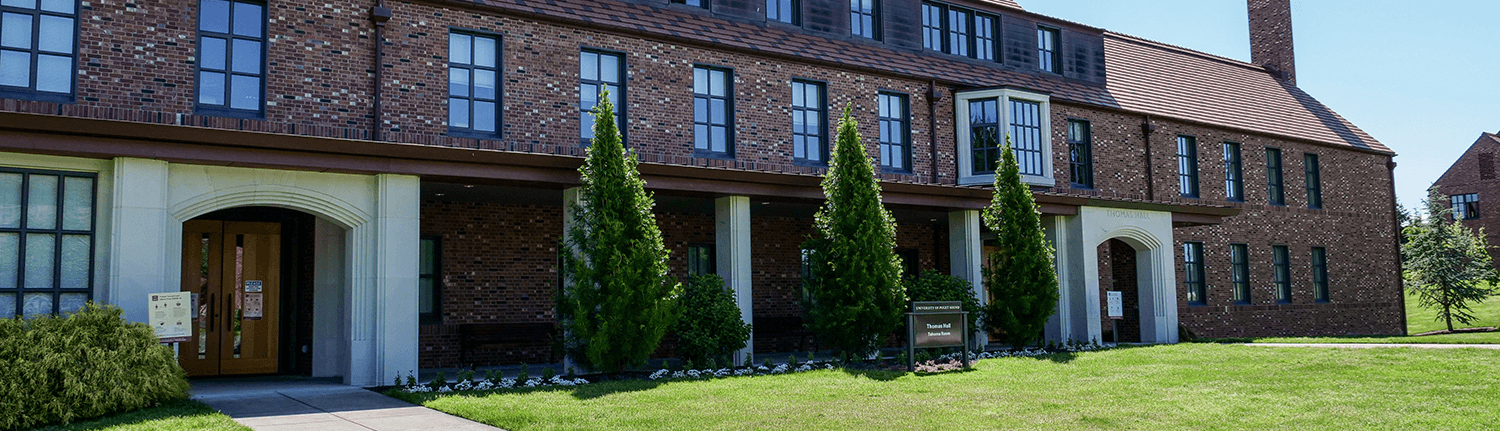 Image of Thomas Hall featuring the two front entrances and foliage.