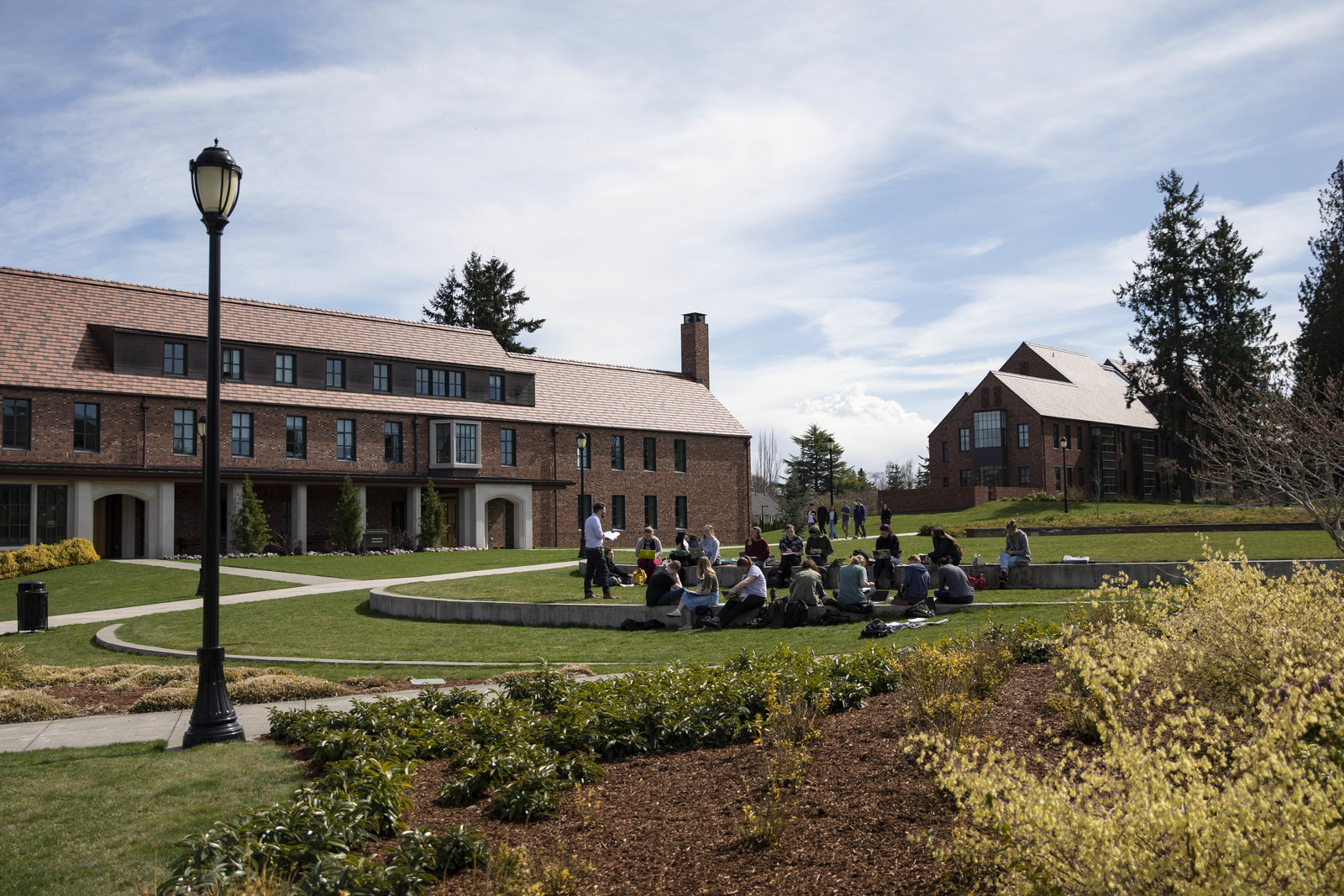 A student group sitting down outside on campus lawn