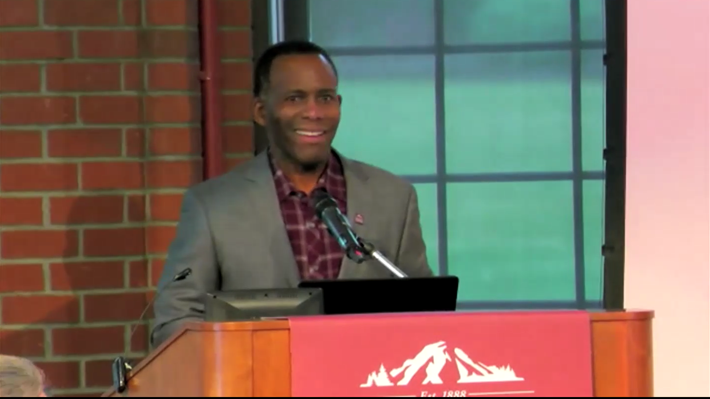 Screenshot of President Crawford standing behind a podium in Rasmussen Rotunda