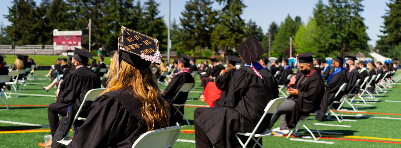 Graduates sit on Peyton Field for Commencement 2021