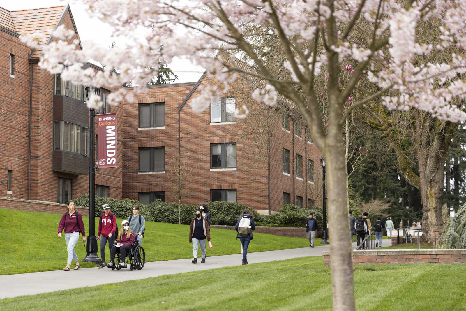 Campus members and visitors make their way along the sidewalk between Howarth Hall and Trimble Hall