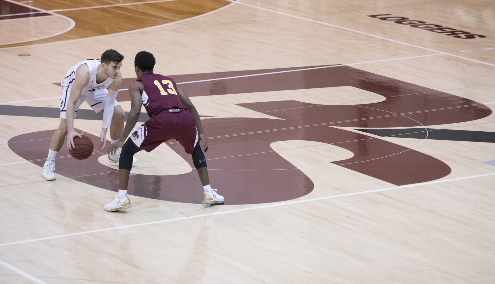 Basketball players on the PS on the key on the court in Warner Gym