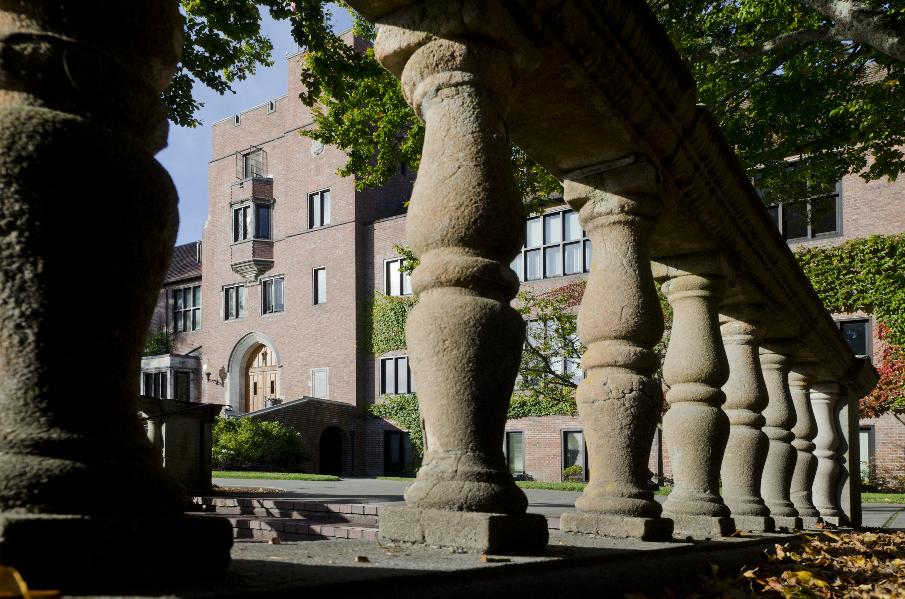 Cement columns with a brick building peaking between the rows. 