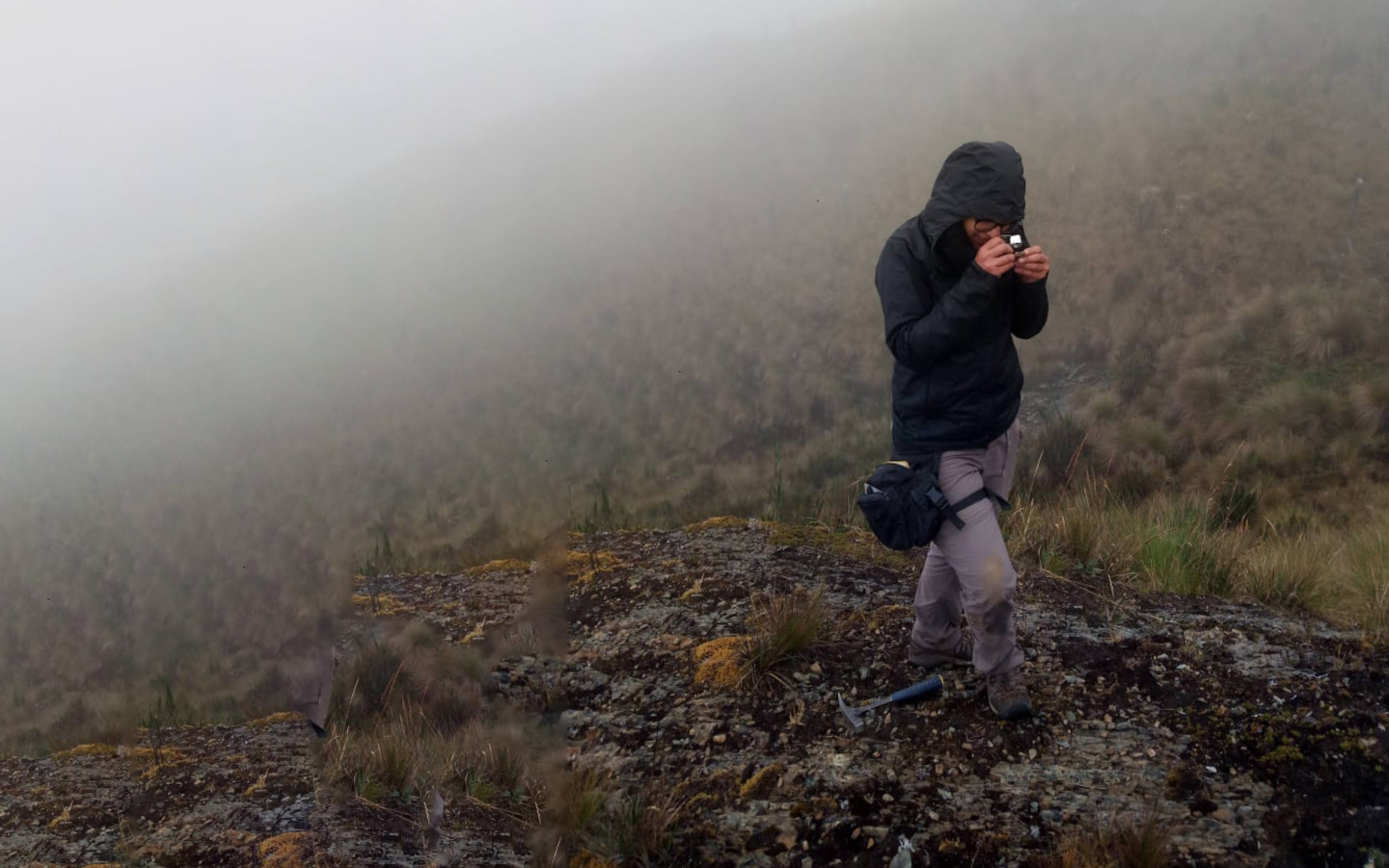 Student researching outdoors in mountain terrain