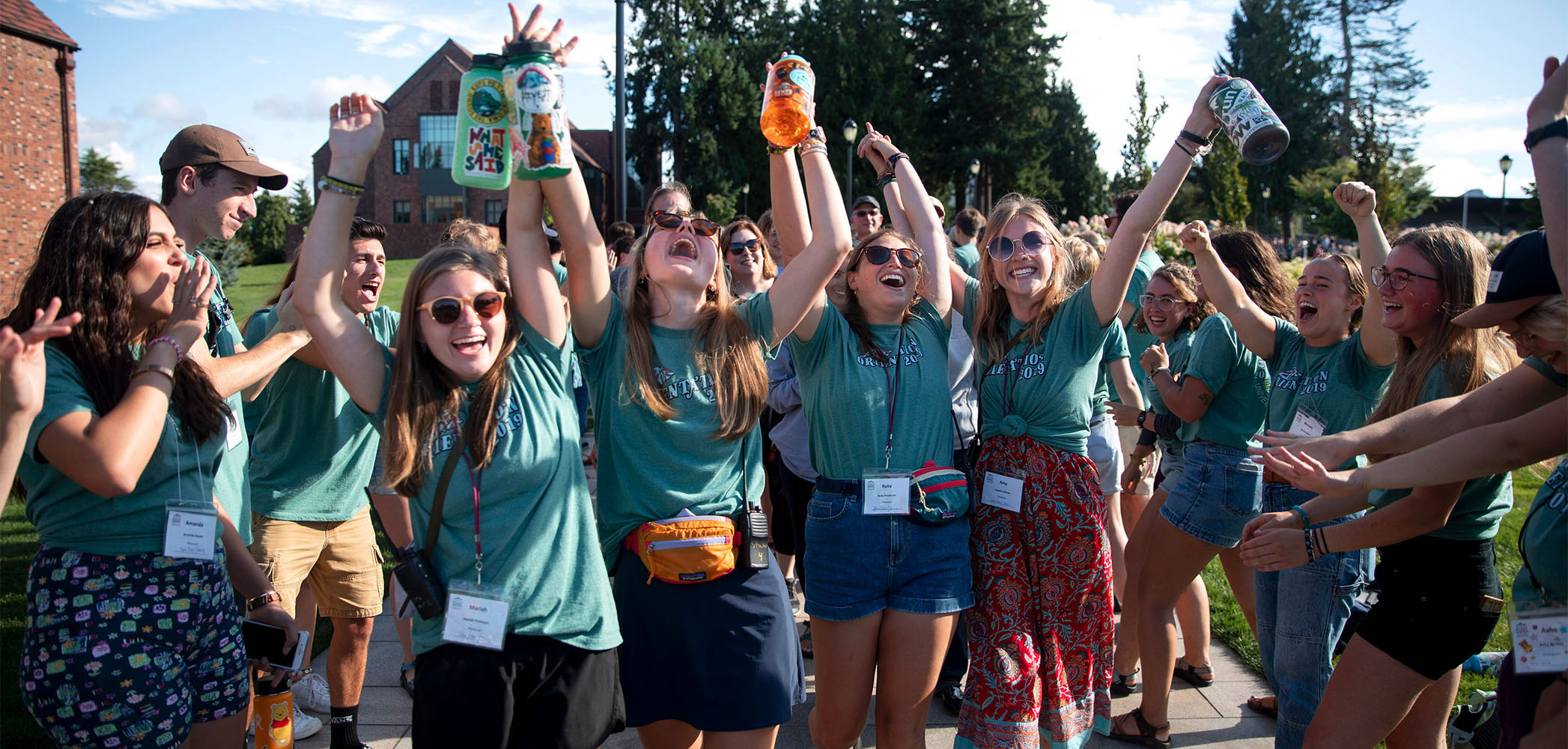 A group of students cheering with arms up in excitement