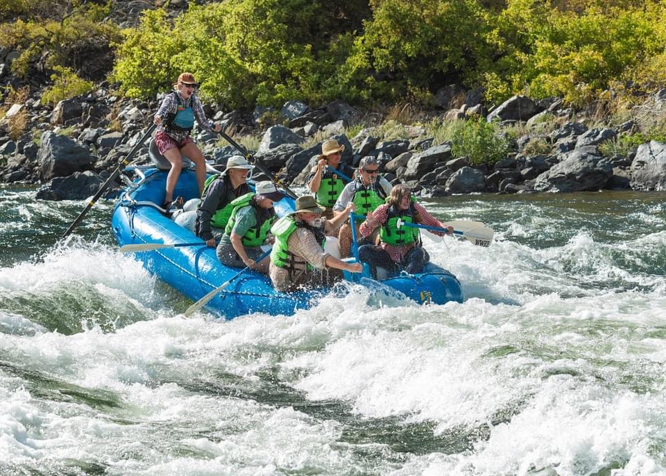 People wearing life vests on a river rafting trip