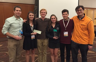 Six people smiling with an award.