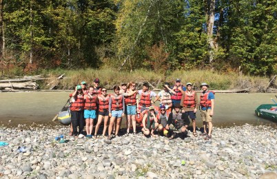 Some people standing in front of a river.