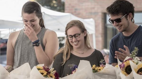 Students explore flower arrangements at the Proctor Farmers Market.