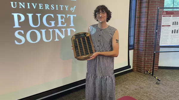 Hayden Smith '23 holding up the Abigail Mattson award plaque at the graduation reception