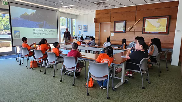 A group of students listening to a presenter