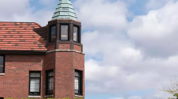 Campus residence hall silhouetted against a blue sky with white clouds