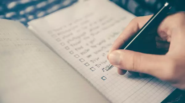 Hand writing a to-do list in a bullet journal