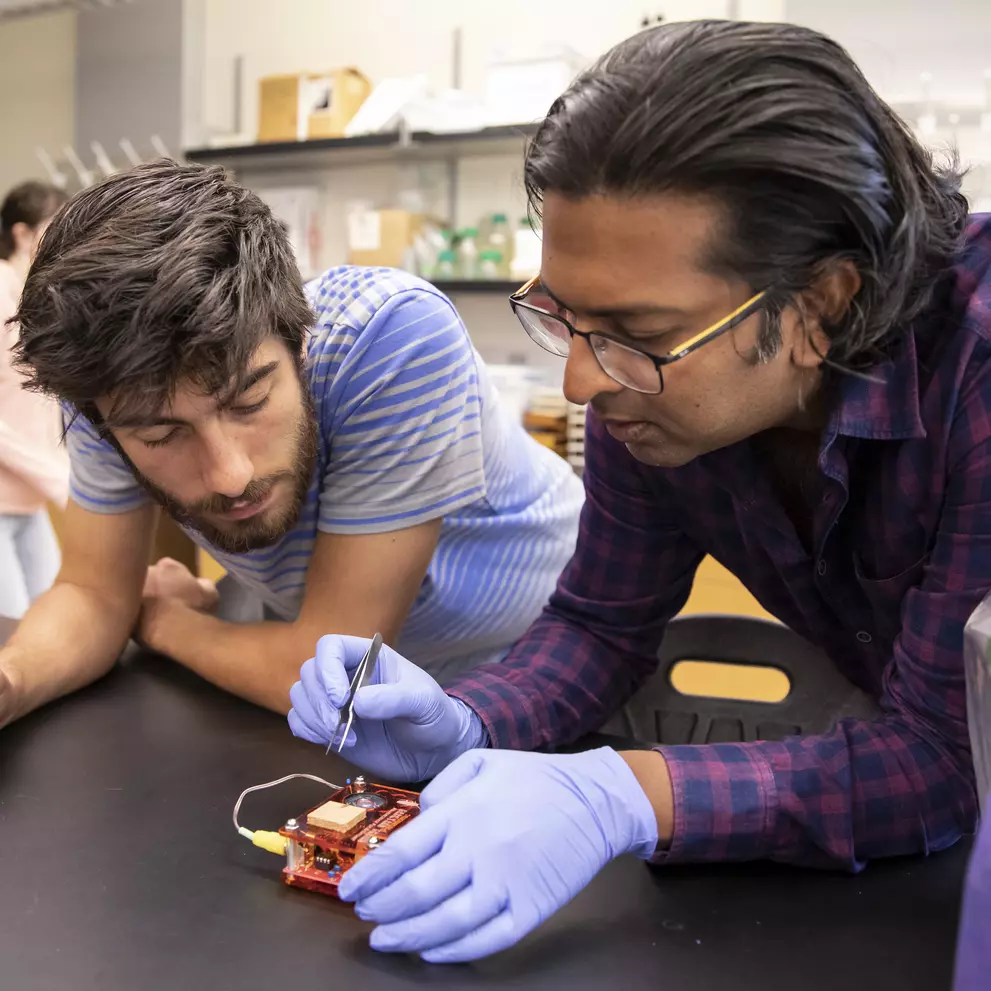 Prof. Siddharth Ramakrishnan works with a student on a project.