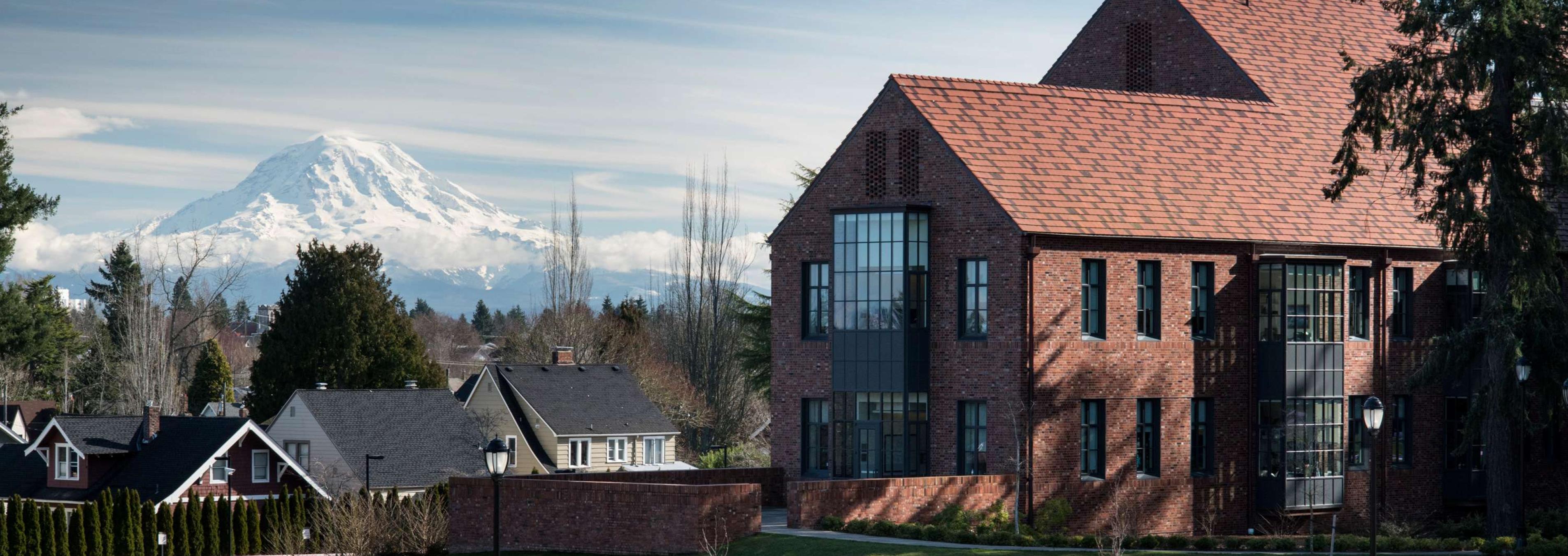 Students walking near Weyerhaeuser Hall and the Event Lawn with Mount Rainier in the background