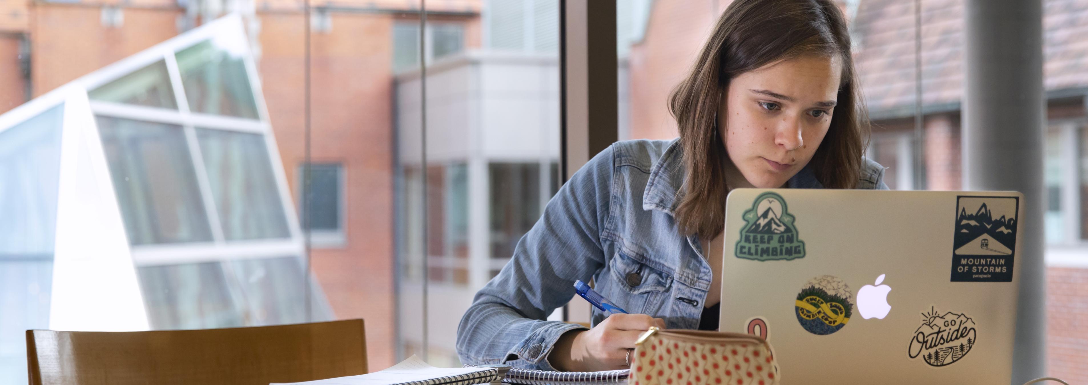 A student studies with a laptop in Thompson Hall.