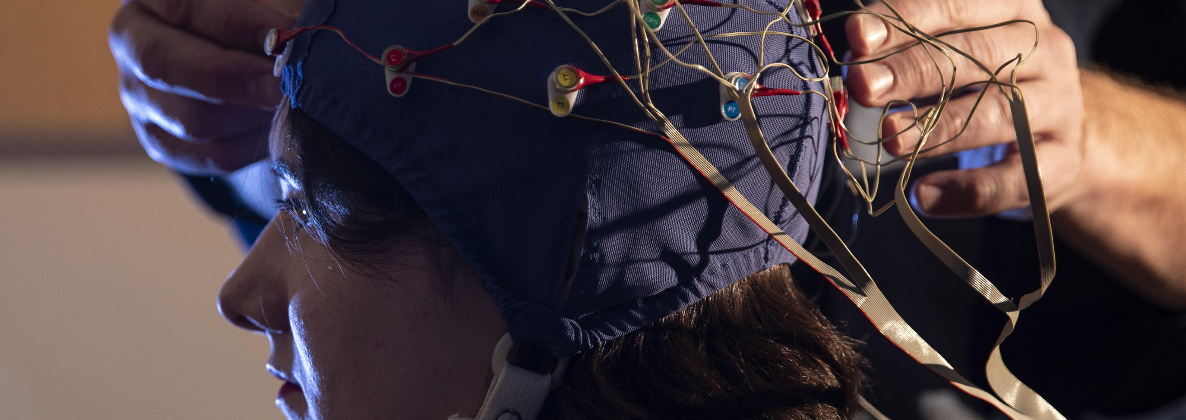 Student taking part in a study with an electrode cap on their head