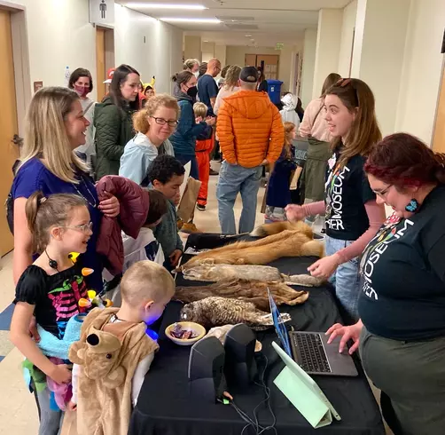 Student docents showing specimens to children