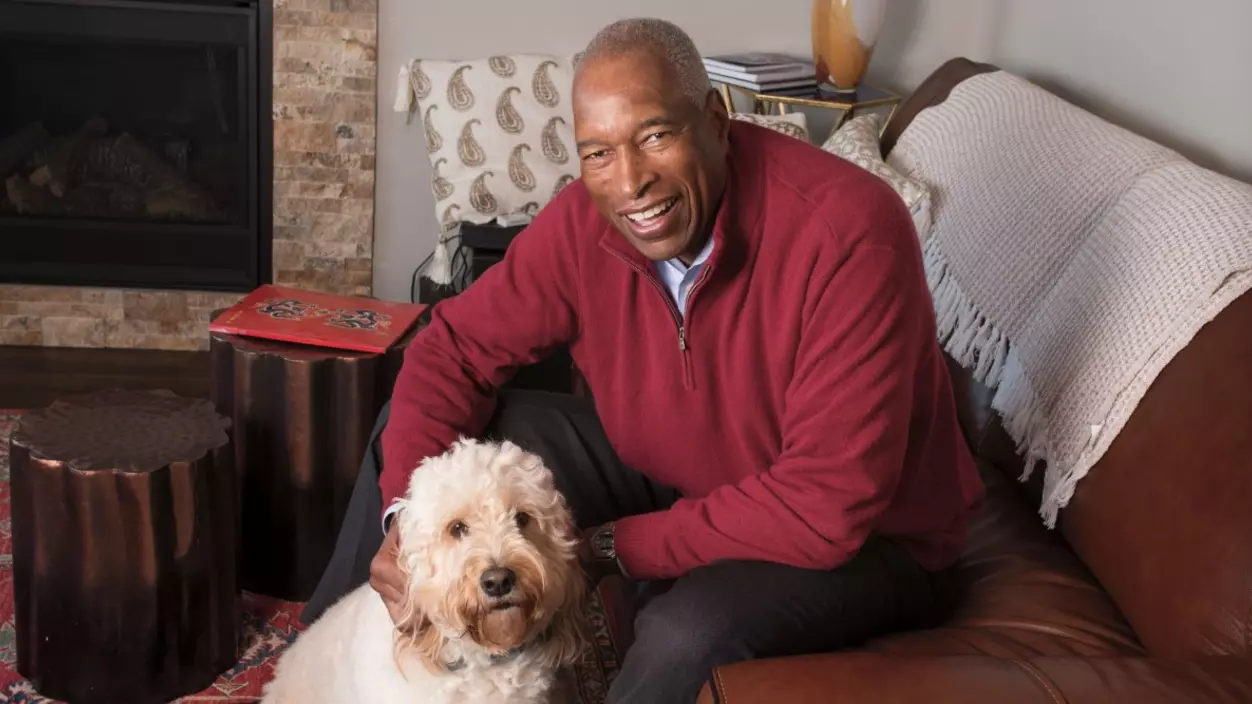 Man sitting on a couch petting a dog