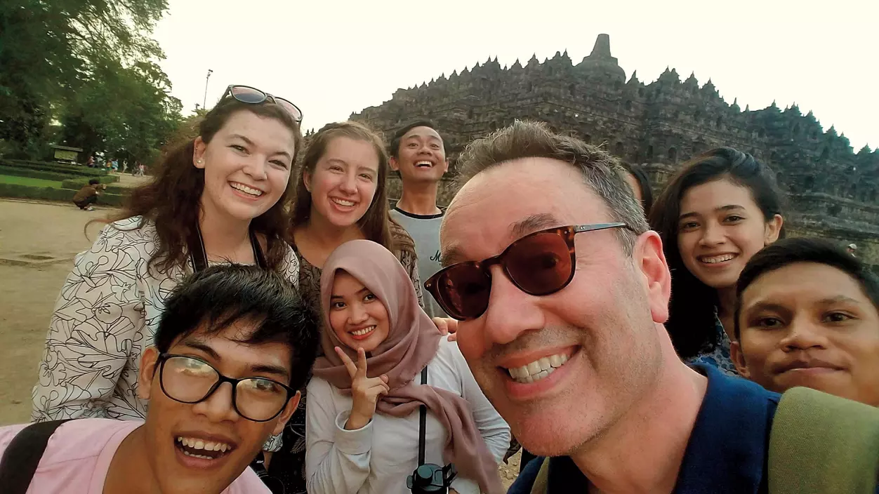 A group of people posing in front of a Buddhist temple