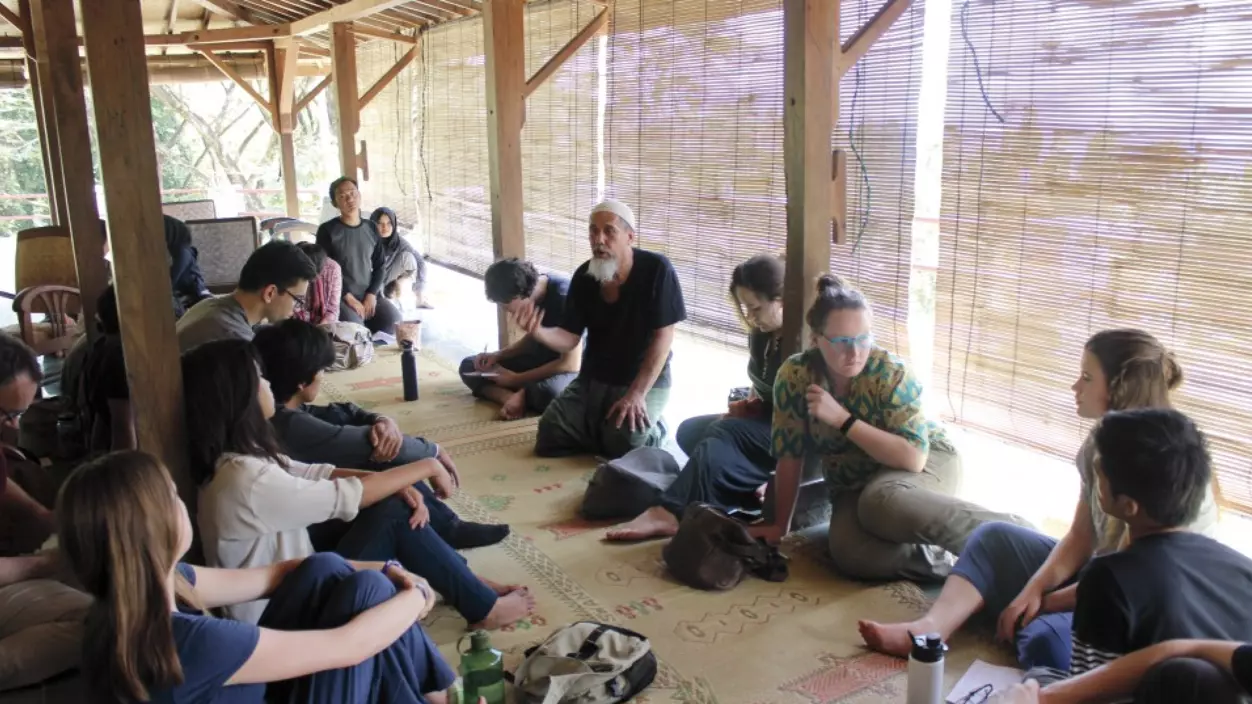 A group of people sitting outdoors having a discussion