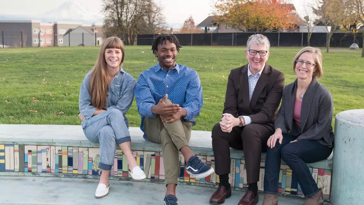 Four people sitting and smiling and talking