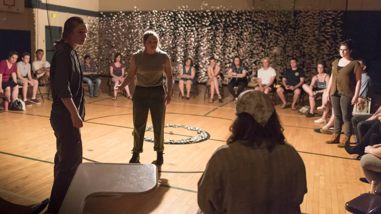 Group of people participating in a theater exercise in a gymnasium