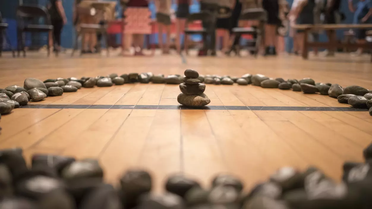 A group of stones arranged in a circle, with a small stack of stones in the center of the circle