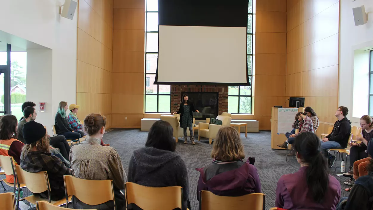 A person speaking to an audience in a presentation room