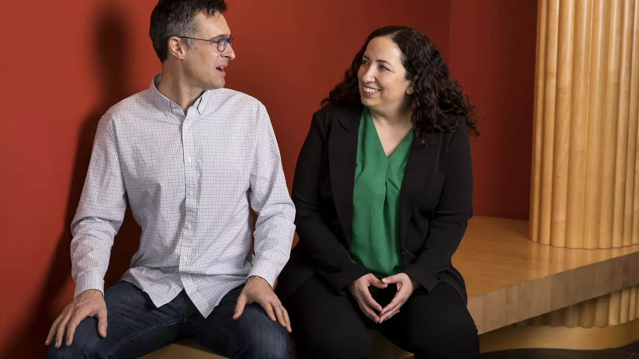 Two people talking and sitting on a bench