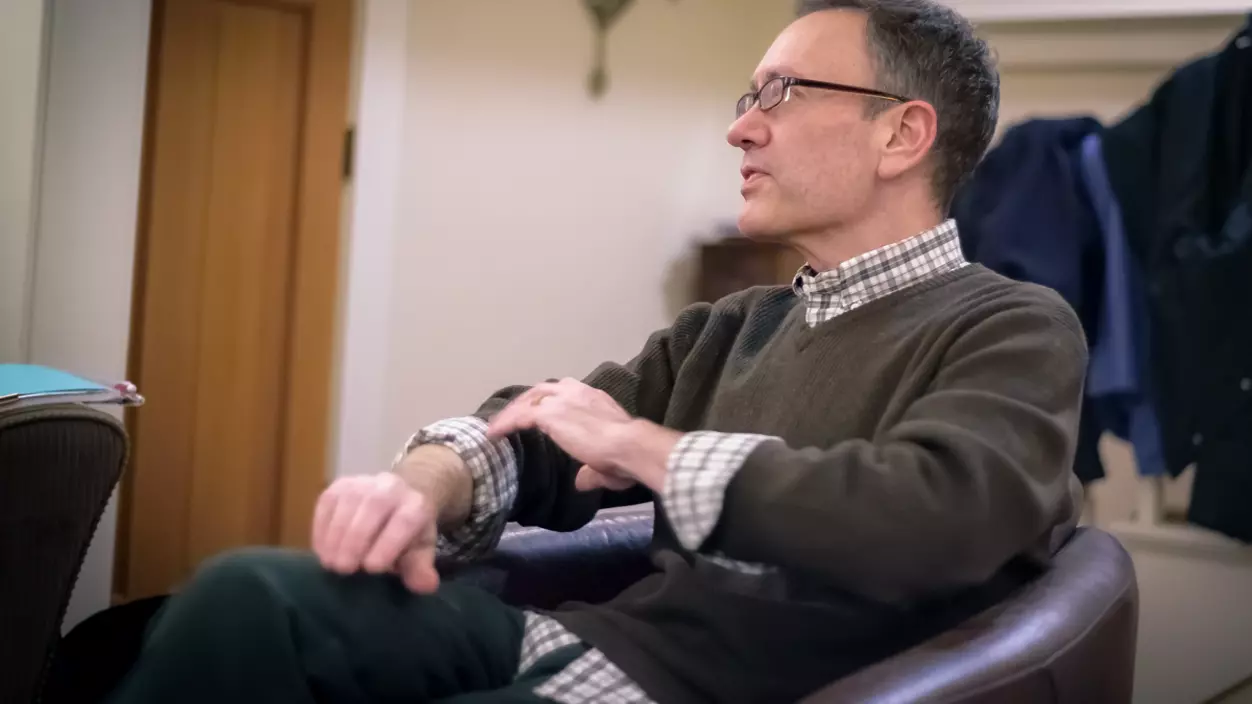 A person sitting in a chair and talking