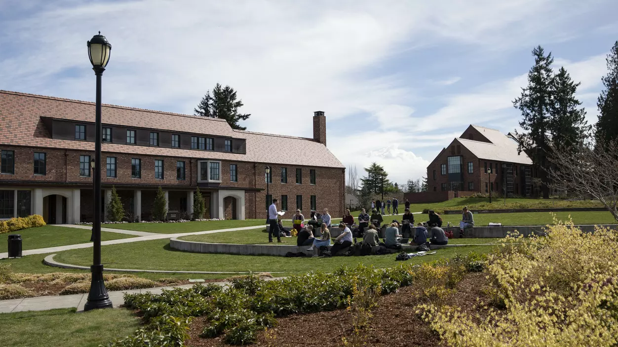 A group of people sitting in a garden lawn space