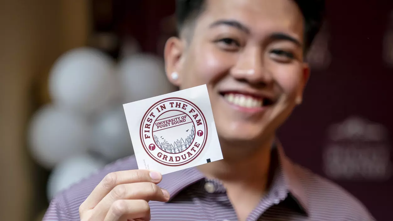 First Generation Logger Graduate holding up a First in the Fam sticker