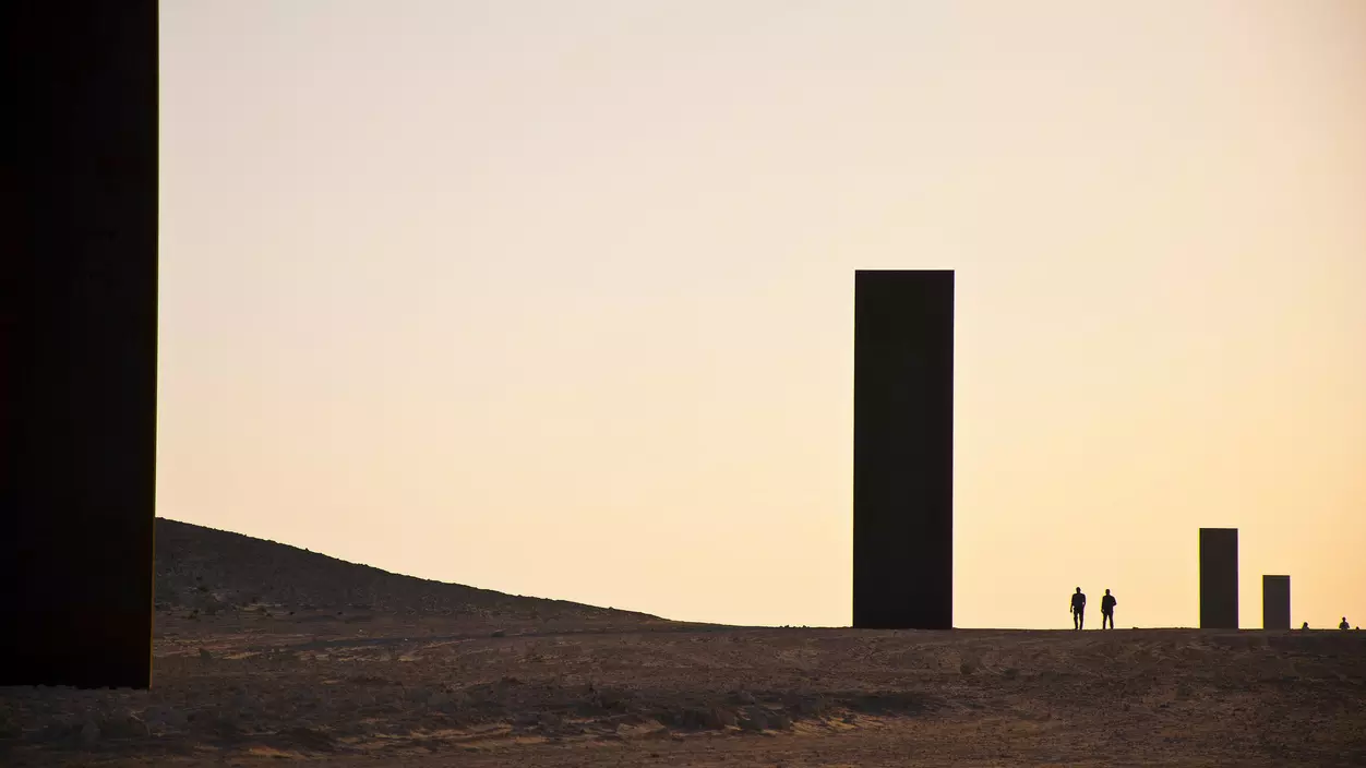 Monoliths against the sky at twilight, this sculpture by Richard Serra is called East-West/West-East.