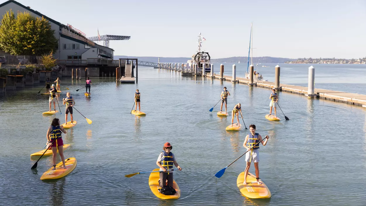 Students paddleboarding in Commencement Bay as part of an experiential learning activity.