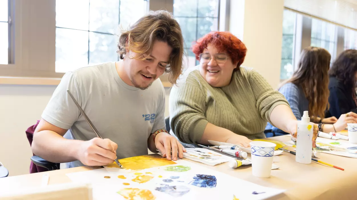 Two students work on an art project in the classroom.