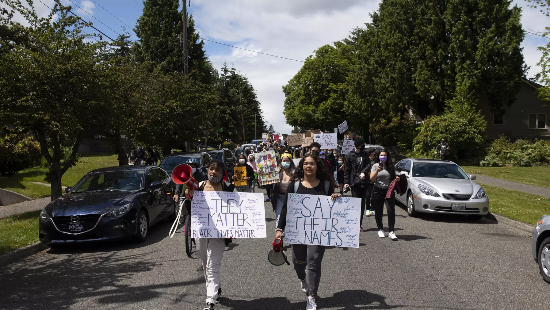 Protestors marching down a road with signs