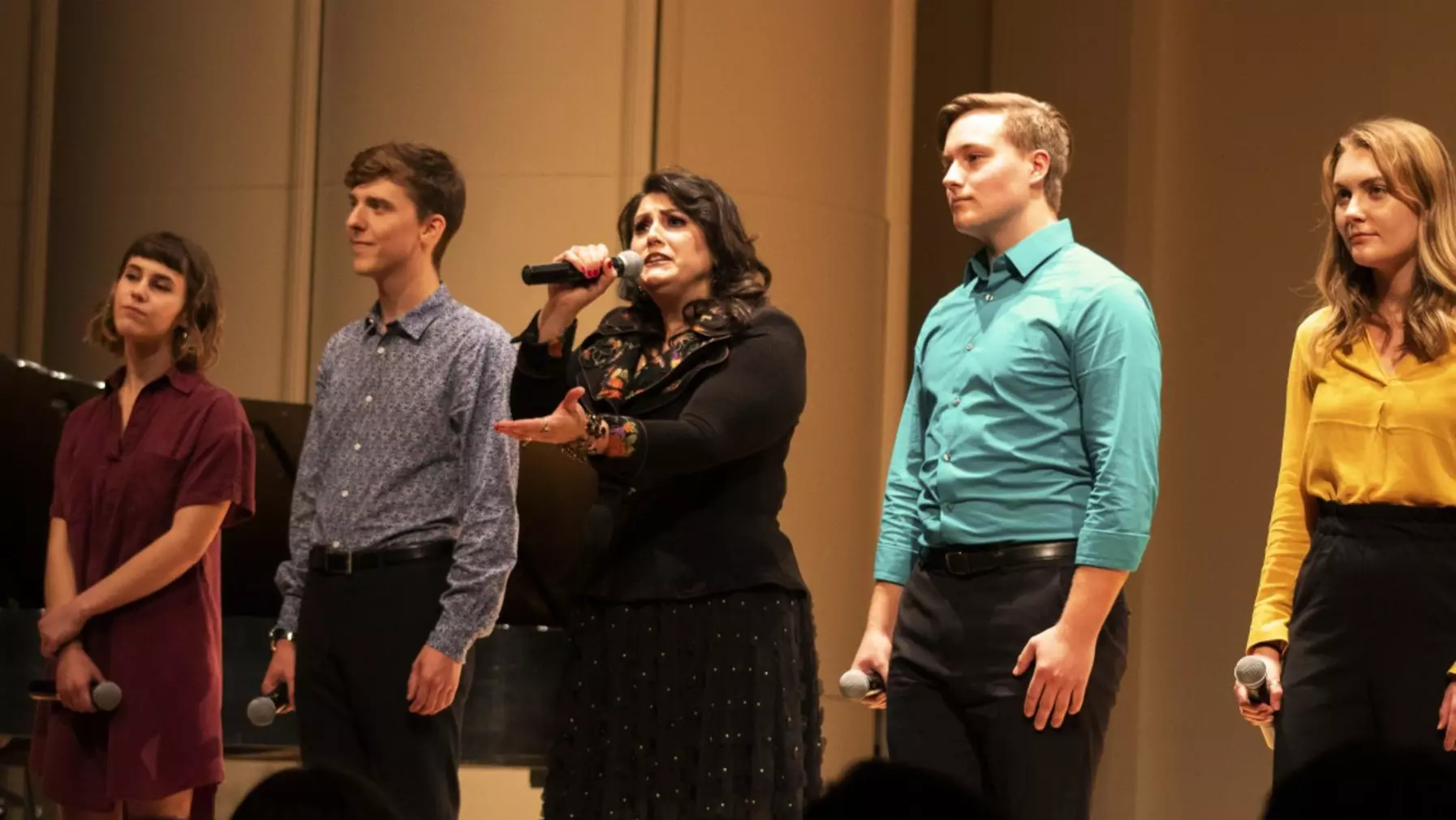 People holding microphones on stage