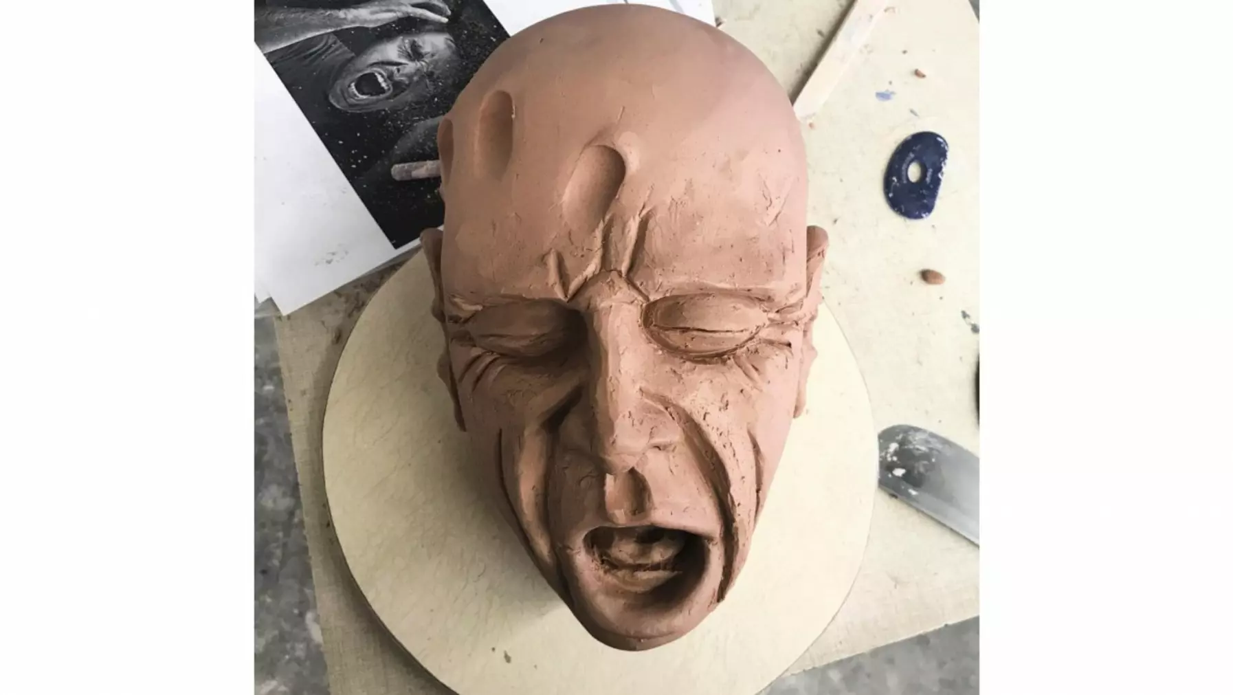 clay sculpture of a face in progress