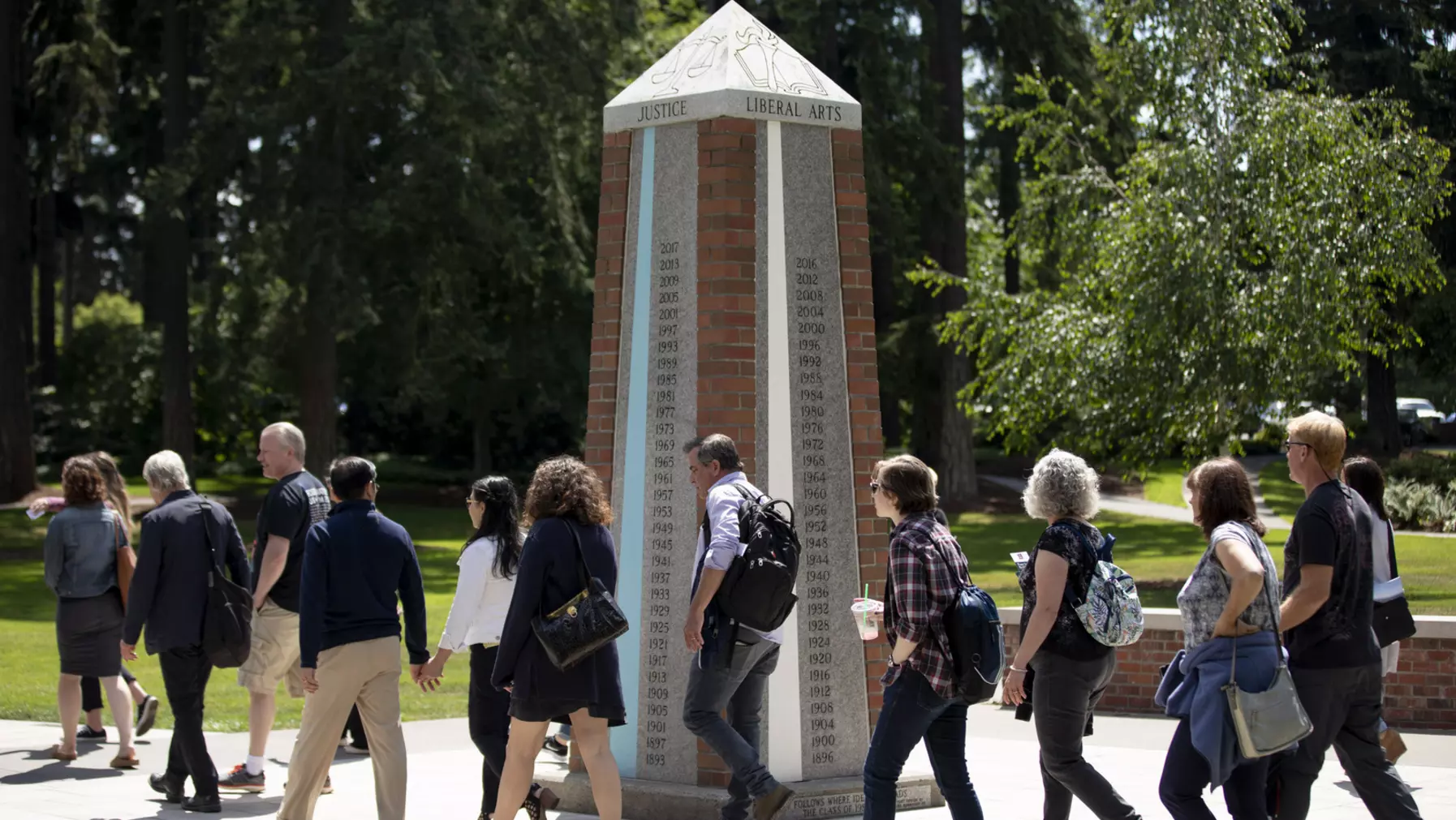 Students and families at orientation file past the Color Post