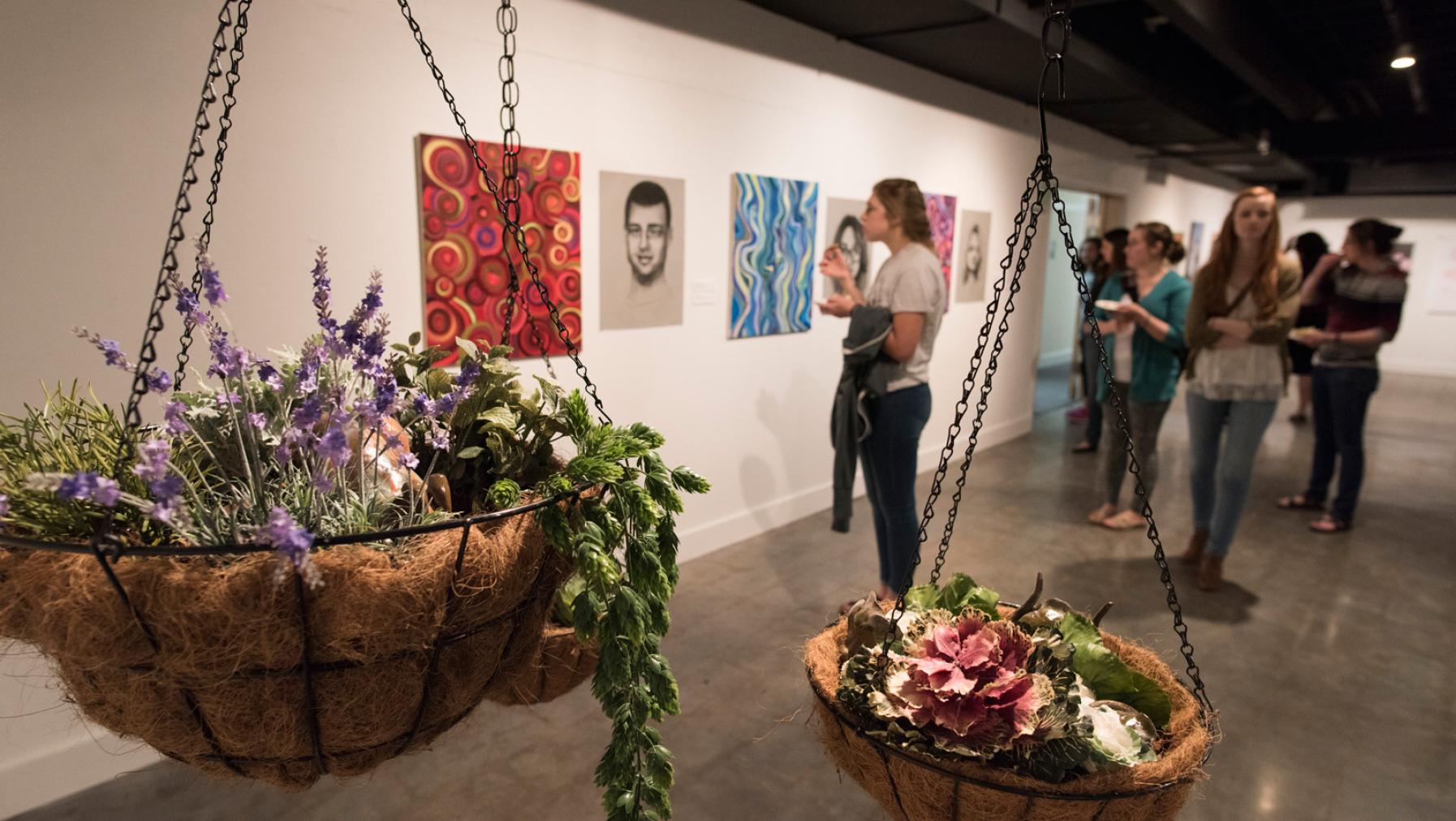 People looking at art on display in a gallery setting