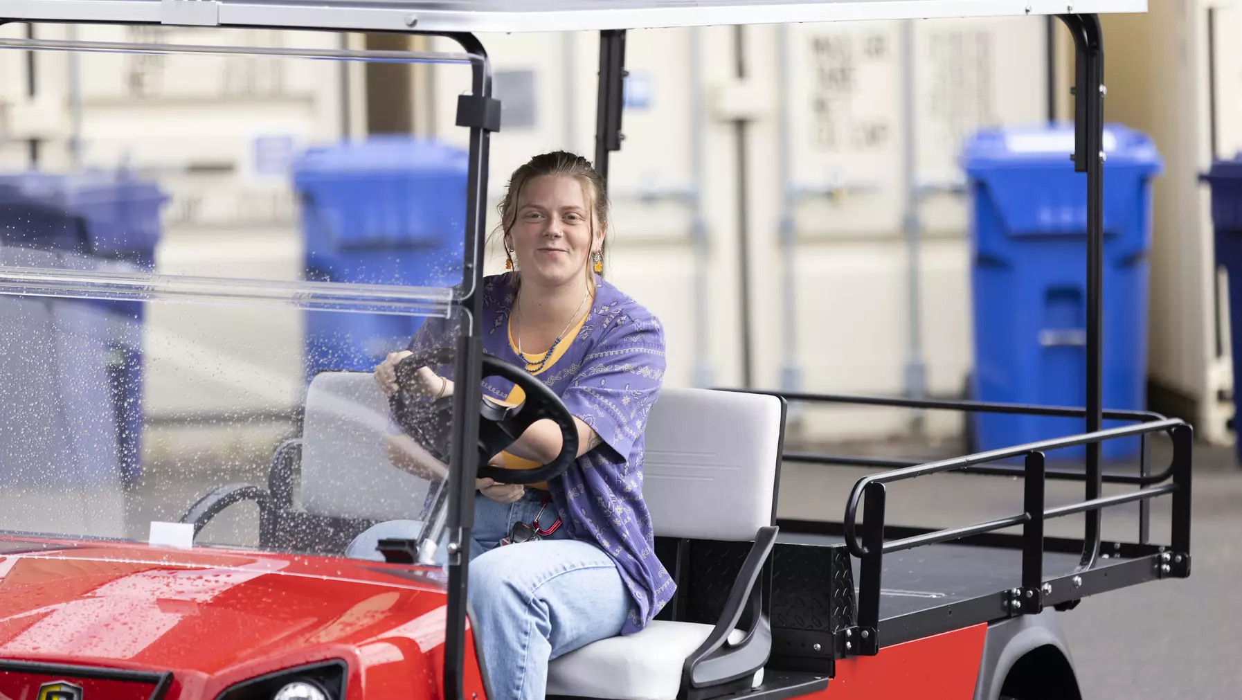 Kaylynn O'Curran ’23 driving a golf cart on campus.